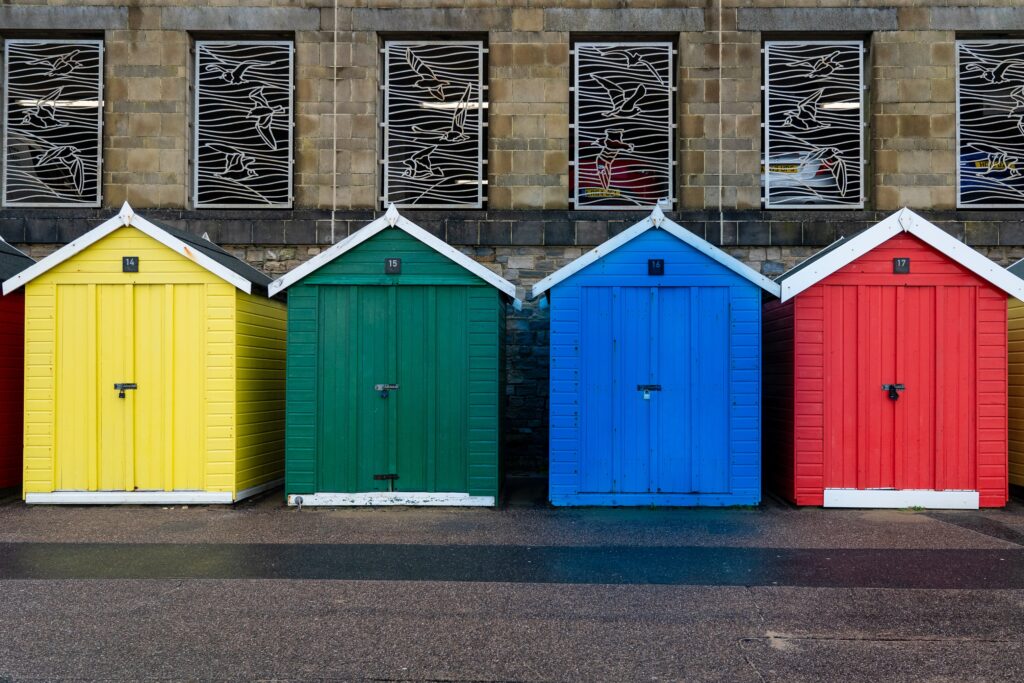 four beach huts in different colours