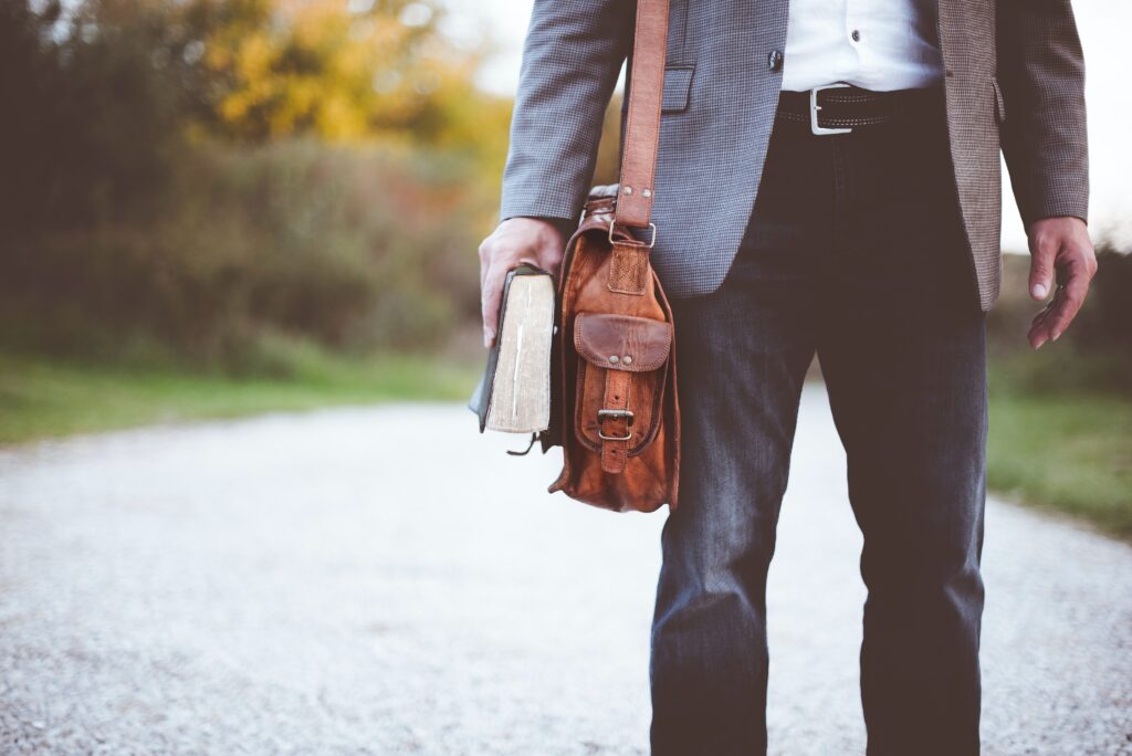 man holding a bag and a book