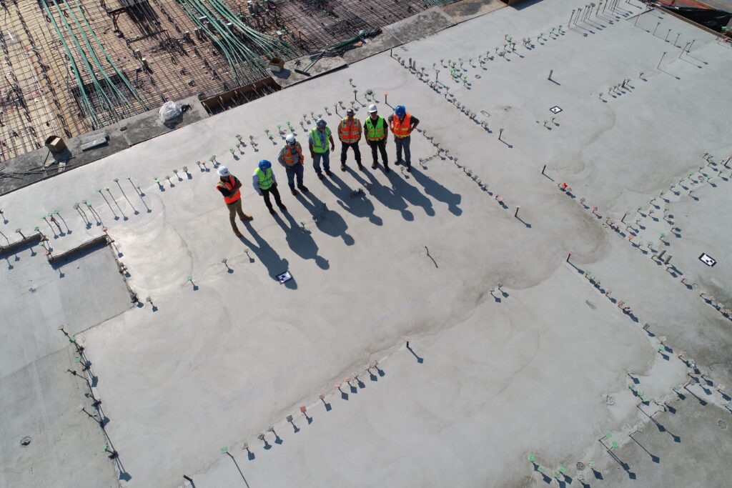 construction workers standing on the top of a building